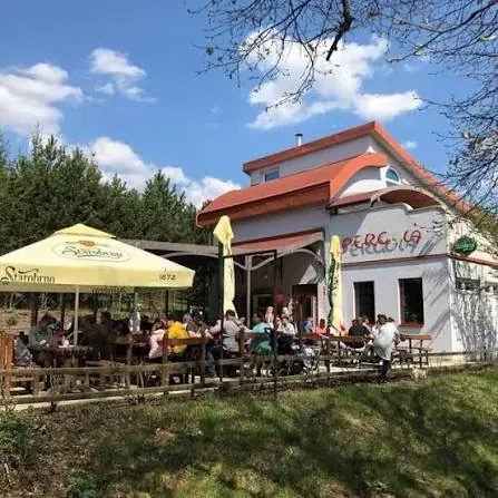 Terasa Bistra Pergola pod slunečníky, bílý domek s červenou střechou